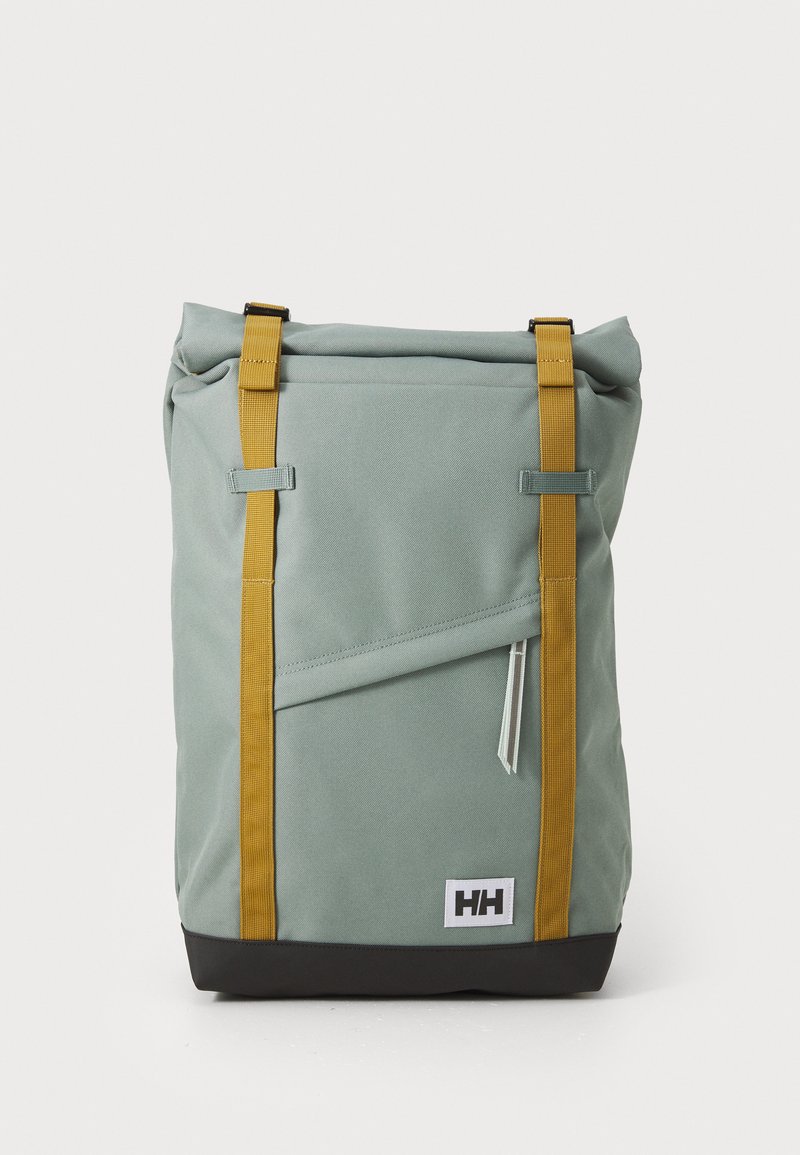 Zaino roll-top verde chiaro con spallacci gialli e fondo nero. Presenta una tasca anteriore con zip e una toppa con logo alla base.