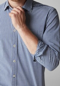 Koszula w kratę w niebiesko-bia�łe kolory. Posiada kołnierzyk, długie rękawy oraz klasyczne guziki w wzór gingham.