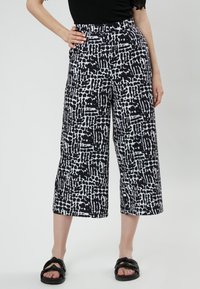 Zwart-wit gepatteerde wijde broek met een uniek abstract ontwerp, voorzien van een hoge taille en cropped lengte.