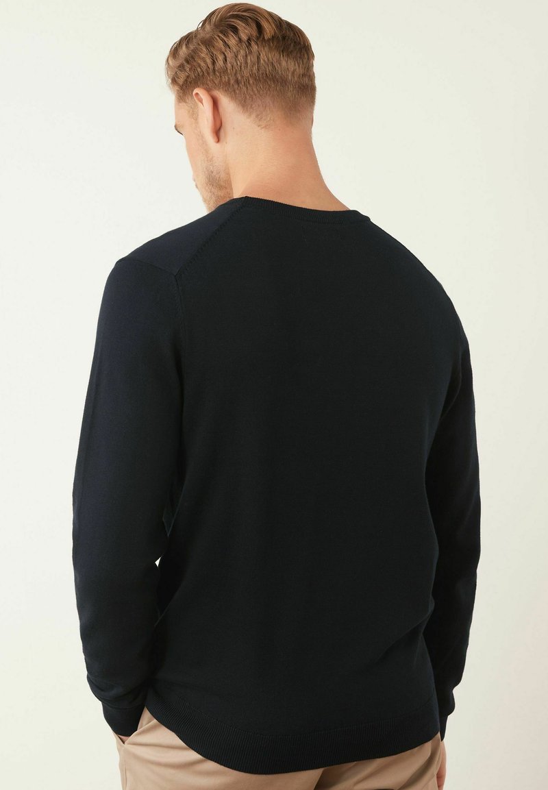 Dunkelblauer Pullover aus Strickstoff, mit rundem Halsausschnitt, langen Ärmeln und gerippten Bündchen und Saum. Glatte Textur mit einer taillierten Passform.