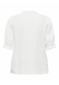 Blouse blanche texturée à manches courtes avec des poignets retroussés et un petit col, vue de dos sur un fond uni.