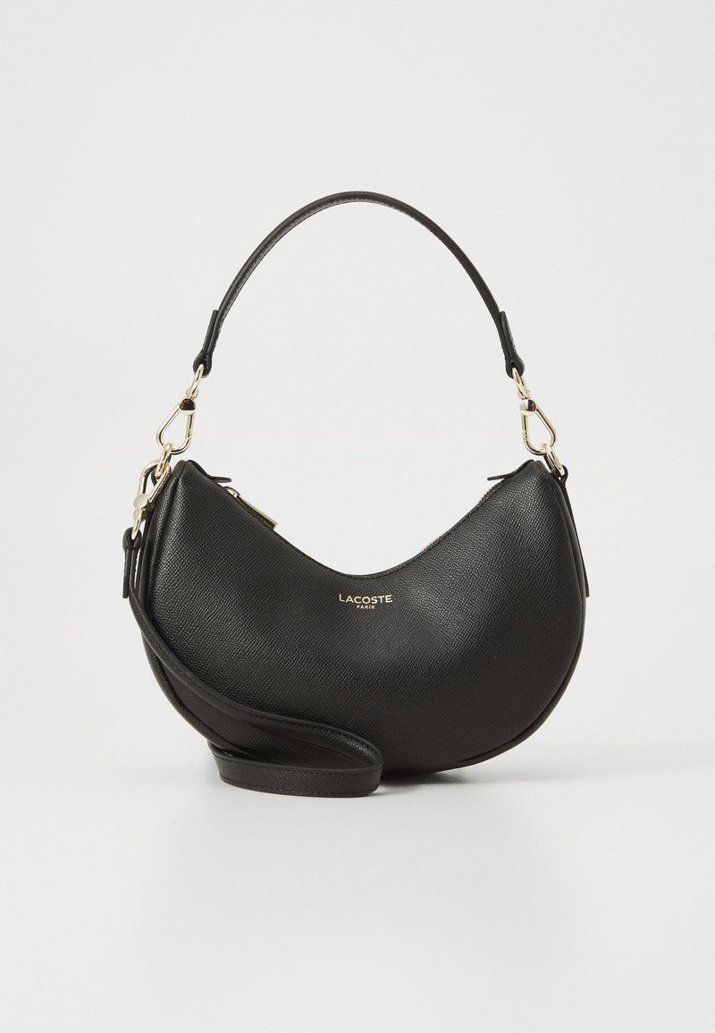 Fekete bőr kézitáska ívelt dizájnnal, arany hardware kiegészítőkkel és vállpánttal. Textúrált felülettel és márkajelzéssel rendelkezik.