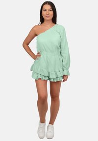 Mintgroene off-shoulder rompert gemaakt van textuurstof met een rimpelende zoom. Kenmerkt een fitted taille en lange mouw met elastische manchet.