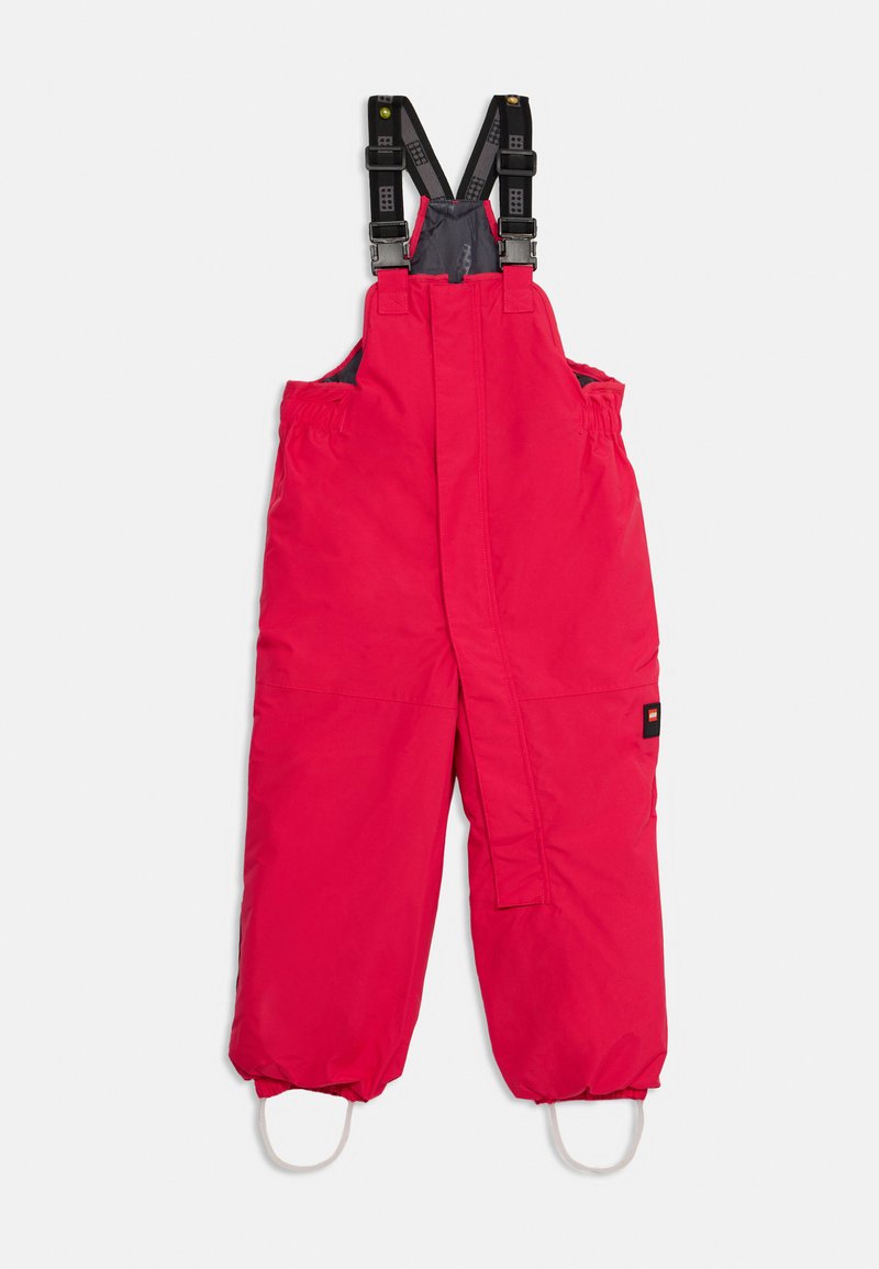 Salopette isolante rossa con spallacci neri regolabili, polsini elasticizzati, tasche laterali e una toppa con logo sulla coscia sinistra.