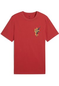 Camiseta de algodón roja con cuello redondo, mangas cortas y un pequeño logo de Puma amarillo y negro en el lado izquierdo del pecho. Textura suave.