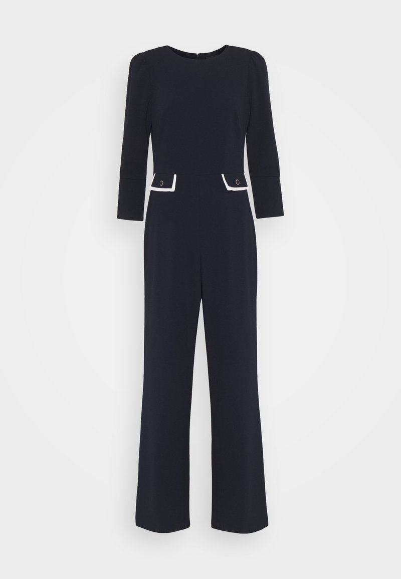 Navy blue jumpsuit with long sleeves, round neckline, and contrasting white pocket accents. Straight leg design, made from smooth fabric.
