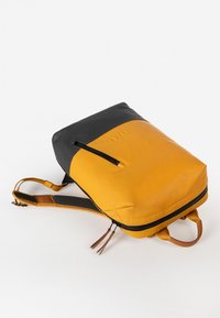 Geel en zwarte rugzak met een rechthoekige vorm, gemaakt van duurzaam materiaal, met een voorzak met ritssluiting en getextureerde banden.