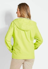 Leuchtend gelbe, wasserdichte Jacke mit Kapuze, die eine glatte Textur und ein einfaches Design aufweist. Verfügt über verstellbare Bündchen und eine lockere Passform.