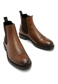 Brązowe skórzane botki Chelsea z wąskim noskiem, elastycznymi bocznymi panelami i teksturowanym czarnym kołnierzem, z płaską gumową podeszwą.