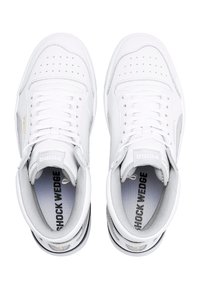 Paire de baskets blanches Puma Shock Wedge avec détails perforés et lacets, vue de dessus sur fond blanc.