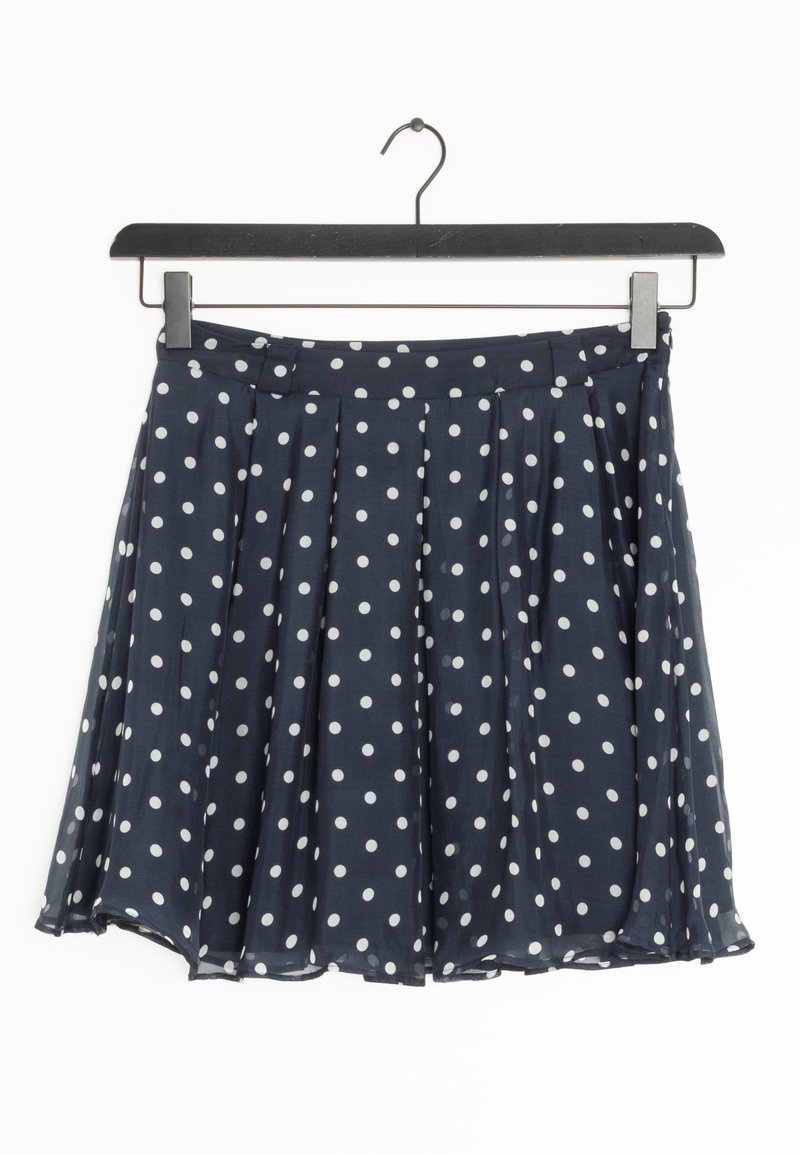 Navy polka dot skirt made of lightweight fabric, featuring pleats, a waistband, and an above-the-knee length design. Soft texture.