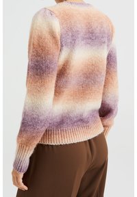 Pull en maille avec un dégradé de teintes orange, crème et violet. Poignets et ourlet côtelés pour plus de texture. Encolure ronde classique.