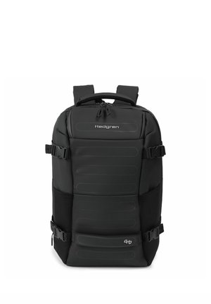 Sac à dos Hedgren noir avec panneau avant rembourré, double fermeture éclair, sangles de compression latérales et poignée de transport supérieure sur fond blanc.
