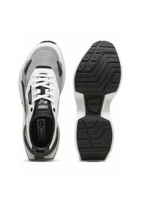 Scarpe sportive con una tomaia bianca arricchita da accenti neri e grigi, suola testurizzata e motivo a griglia sui lati per supporto e stile.