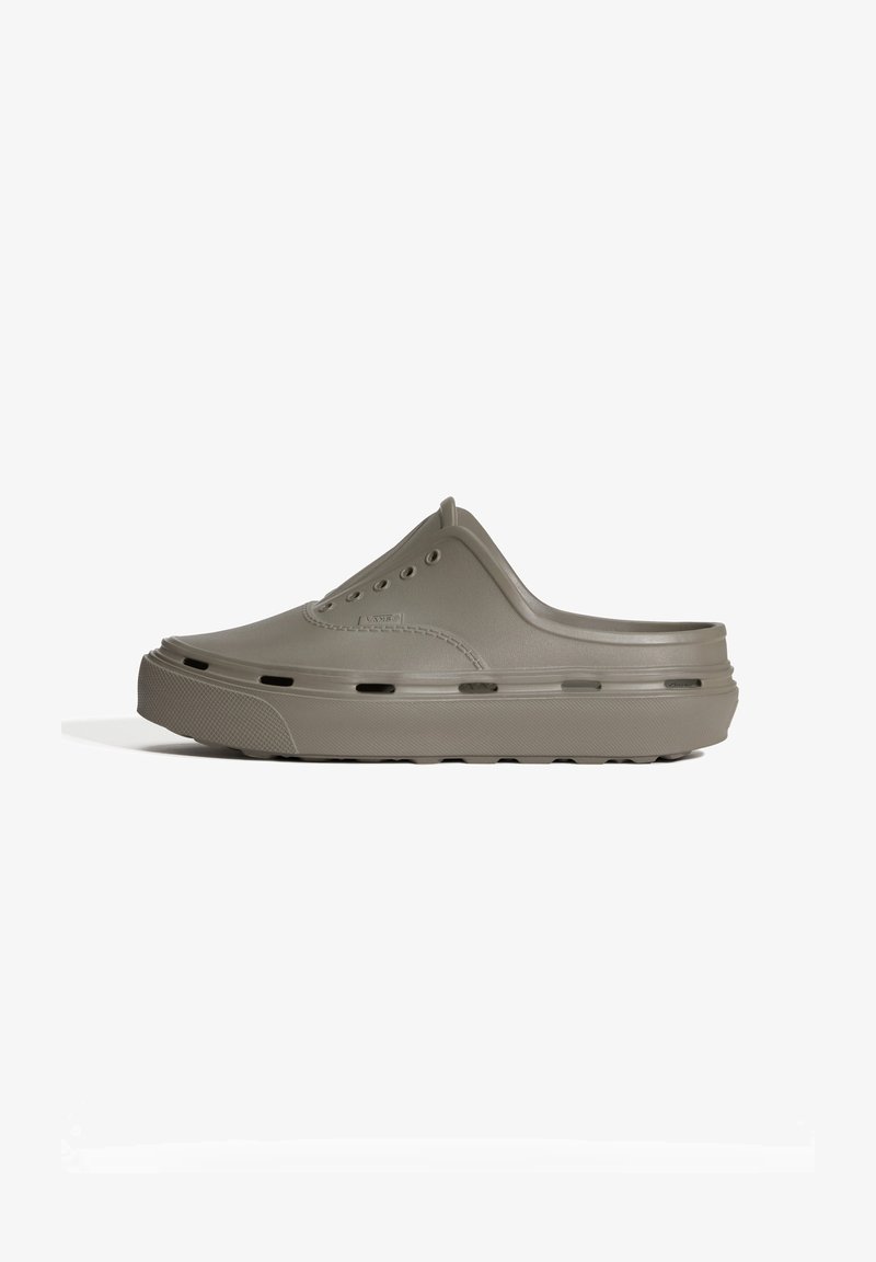 Chaussure style sabot à enfiler en caoutchouc gris avec trous de ventilation latéraux et semelle texturée, vue de côté extérieur sur fond blanc.