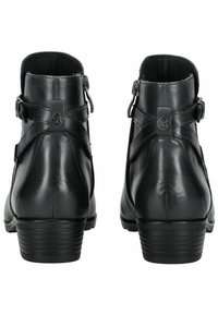 Botas de cuero negro hasta el tobillo con una textura suave, cierre de cremallera, detalles decorativos de hebilla y un tacón apilado.