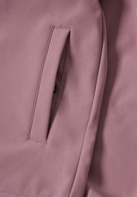 Rosa Jackenstoff mit glatter Textur. Verfügt über eine Seitentasche mit verdecktem Design und präziser Naht entlang der Kanten.