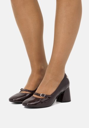 Bruine gepatenteerde lederen schoenen met blokhak, vierkante neus en verstelbare band met een zilveren sluiting. Glad oppervlak met glanzende afwerking.
