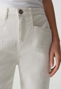 Lichtbeige denim broek met een voorknop met logo, schuin geplaatste zakken en een gestructureerde stof, met een slim fit ontwerp.
