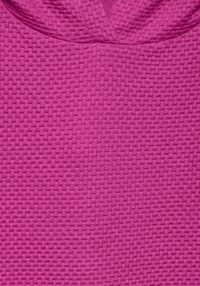 Tela texturizada de color rosa con un patrón elevado y un diseño de cuello en V. La superficie presenta una textura similar a una cuadrícula, lo que realza el interés visual.