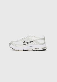Baskets Nike blanches avec des accents argent métallisé, tige en mesh et synthétique, semelle rembourrée et semelle extérieure noire. Présente un logo proéminent.