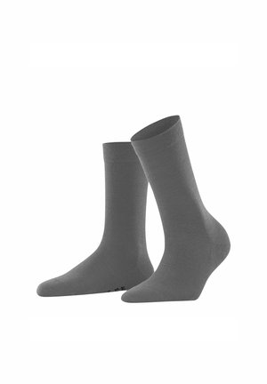 Une paire de chaussettes gris unies, l'une droite et l'autre inclinée, présentées sur un fond blanc.