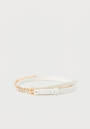 Ceinture blanche à double sangle avec boucle en or, une sangle unie et l'autre ornée de petits strass transparents.