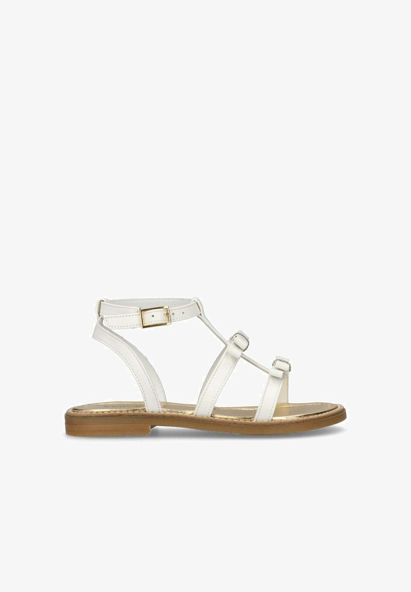 Hvide lædersandaler med tre remme. Justerbar ankelrem med guldfarvet hardware. Flad sål med en subtil metallisk finish.