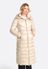 Beige Steppjacke mit taillierter Passform, Reißverschluss, verstellbarem Kapuze und Seitentaschen. Strukturierter Steppmuster und kontrastierende Reißverschlussakzente.