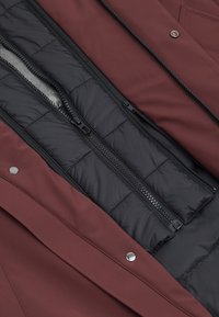 Bordowa kurtka z czarną, ocieplającą podszewką, wyposażona w podwójne zamki błyskawiczne i srebrne zatrzaski. Tkanina o fakturze ze gładkimi akcentami.