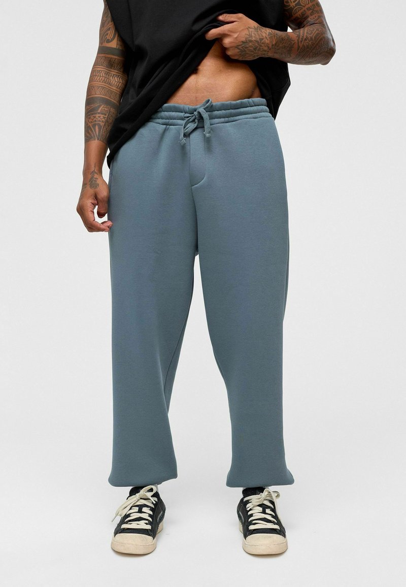 Lichtblauwe sweatpants gemaakt van zachte stof, met een elastische tailleband met trekkoord, zijzakken en een relaxte pasvorm.
