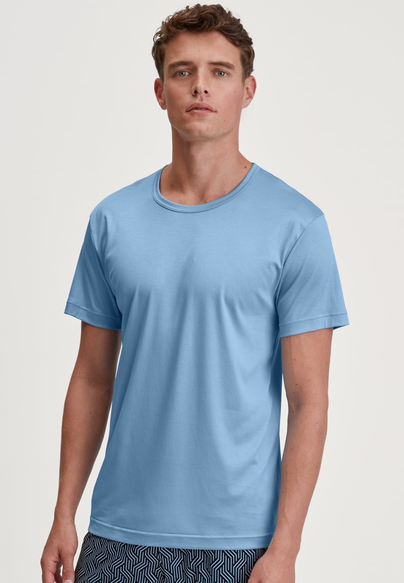 Lichtblauw T-shirt met korte mouwen, ronde hals, gemaakt van een gladde stof, met een ontspannen pasvorm. Draag het over een paar gestreepte shorts met een geometrisch ontwerp.