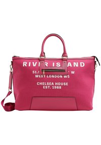 Sac fourre-tout en toile rose avec texte blanc. Dispose de doubles poignées et d'une bandoulière réglable. Inclut un détail de poche zippée.