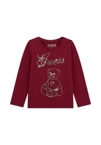 Camicia a maniche lunghe bordeaux con logo "Guess" in paillettes argentate e design di orsacchiotto sul davanti, realizzata in fibra di cotone biologico.