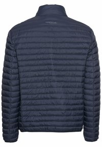 Marineblå polstret jakke med en quiltemønster, høj krave og et diskret logo på ryggen. Letvægts, slanket design.