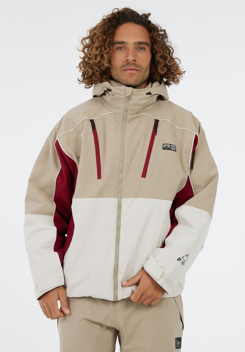 Beige, rode en witte waterdichte jas met een capuchon, rits aan de voorkant en contrasterende gekleurde panelen. Heeft zakken en logo-details.