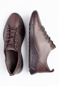 Sneakers in pelle marrone con una texture liscia, punta arrotondata e design con lacci. Presentano una suola flessibile e un logo discreto sul lato.