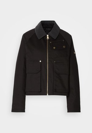 Fekete, rövidített dzseki tartós anyagból, cipzáras elejével, kontrasztos gallérral és több elülső zsebbel, sárgaréz kiegészítőkkel.