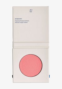 Compact redondeado de rubor que presenta un polvo rosa suave y texturizado en un estuche blanco abierto. La etiqueta indica los ingredientes y detalles del producto.