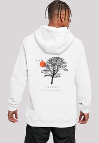 Weißer Kapuzenpullover mit einem schwarzen Baum-Design, einer orangen Sonne und Vögeln. Darunter steht der Text "ENTFLIEHEN UND DIE WELT ENTDECKEN." Weicher Stoff, lässiges Design.