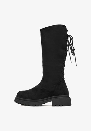 Czarne kozaki za kolano wykonane z zamszu, z teksturowaną powierzchnią, płaską podeszwą i wiązaniem z tyłu. Obcas typu chunky.
