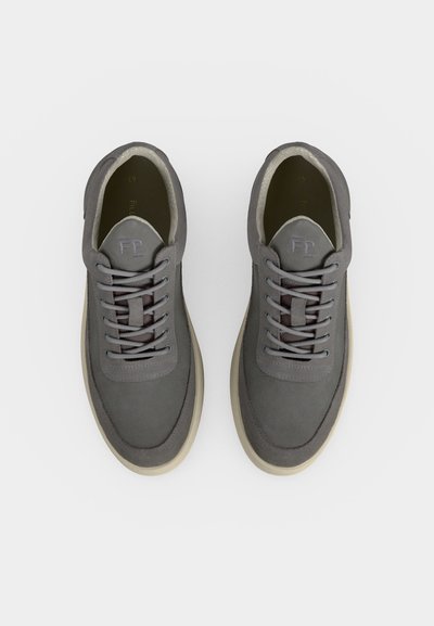 Paire de baskets grises à lacets avec semelles beiges vues de dessus sur fond blanc.