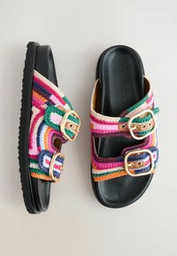 Farverige vævede slidesandaler med to justerbare spænder, sort sål og et levende mønster med nuancer af pink, grøn, orange og blå.