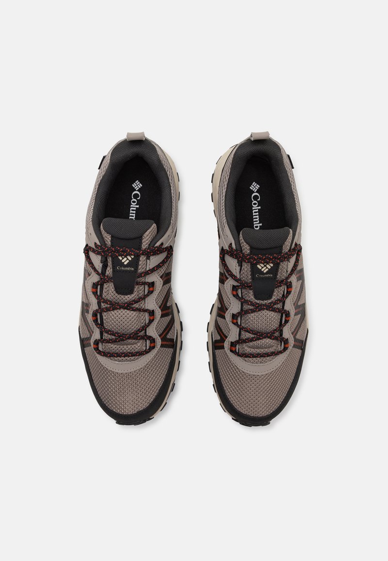 Ein Paar graue und schwarze Columbia-Wanderschuhe mit rot akzentuierten Schnürsenkeln, aus Netzgewebe und mit robusten Sohlen, von oben auf weißem Hintergrund betrachtet.