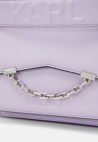 Fialová kožená taška s texturovaným povrchem, stříbrným řetízkem a vyraženým logem "KARL". Čisté linie s kontrastním prošíváním.