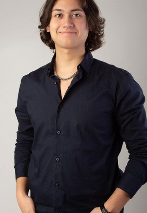 Navy button-up shirt with a slightly textured fabric, long sleeves, and dark buttons. Worn with a silver chain necklace.