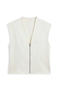 Veste sans manches crème avec un profond col en V et une fermeture éclair à l'avant. Confectionnée dans un tissu doux avec des coutures verticales pour un effet structuré.