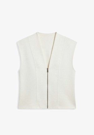 Veste sans manches crème avec un profond col en V et une fermeture éclair à l'avant. Confectionnée dans un tissu doux avec des coutures verticales pour un effet structuré.