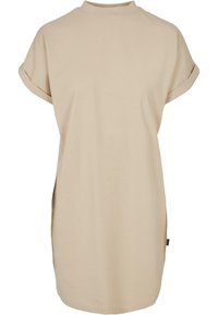 Robe beige à manches courtes avec poignets roulés et col montant, coupe ample et droite avec petites fentes latérales.