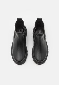 Czarne skórzane botki za kostkę o gładkiej fakturze, z okrągłym noskiem, bocznymi zamkami błyskawicznymi i elastycznymi akcentami, posiadające wytrzymałą podeszwę.